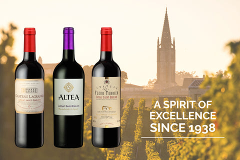 Three  bottles of Lussac Saint Emilion Red Wine with labels in front of a scenic background with a clock tower.